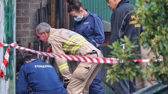 A fire detective, forensics and police from the Arson and Explosives Squad at the scene of a fire where three people died at an unused factory in Footscray. Picture: Hamish Blair