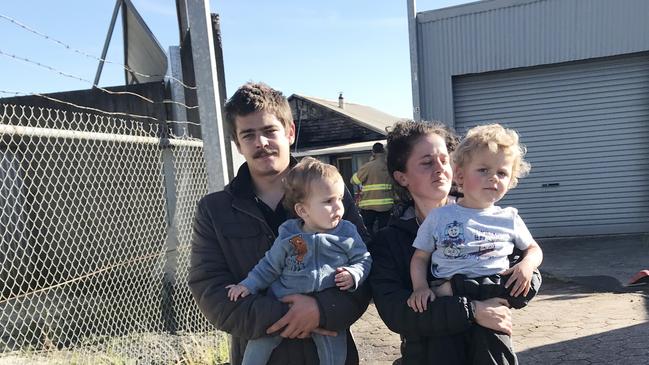 Stephen Edwards and Ella Williams with their two little boys Oliver (2) and Hudson (14 months) outside their destroyed rental property in South Burnie