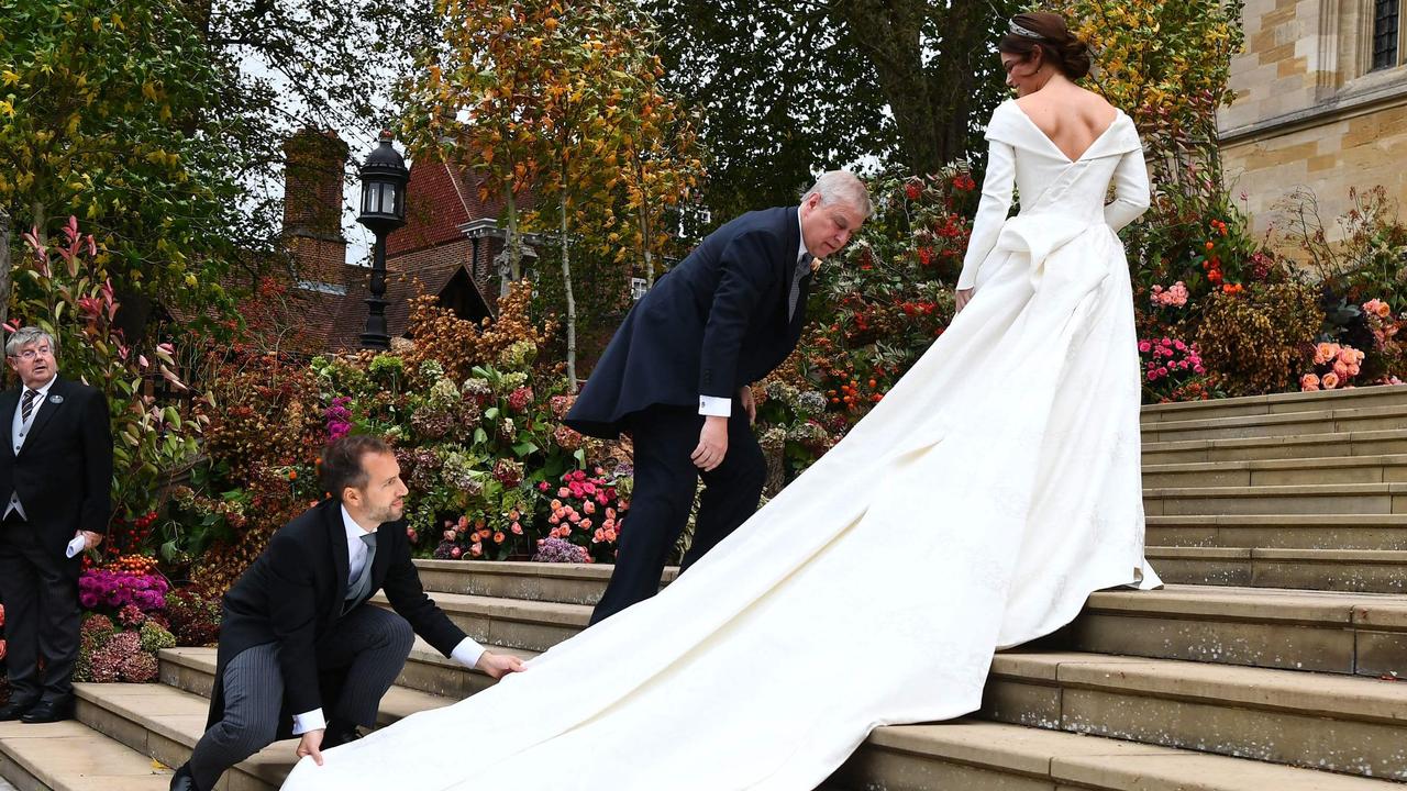 Eugenie’s dress is adjusted as she walks up the stairs to the chapel. Picture: Victoria Jones / POOL / AFP