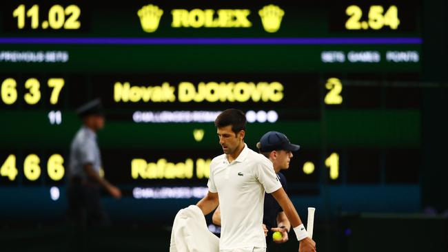 Novak Djokovic leaves centre court after his singles semi-final against Rafael Nadal was suspended. Picture: Getty