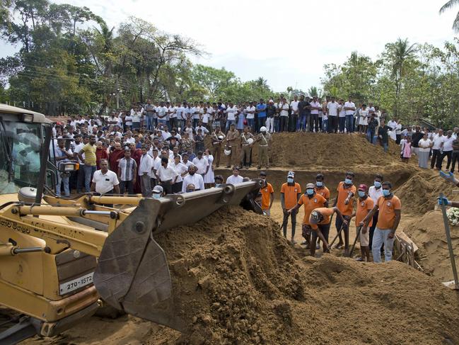 Workers bury victims in a mass funeral for the Easter Sunday bomb blast victims in Negombo. Picture: AP 