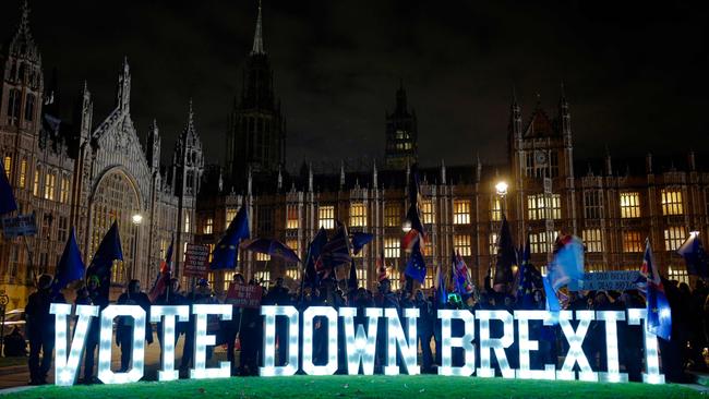 Anti-Brexit demonstrators protest outside parliament with a giant "Vote Down Brexit" spelled out in illuminated letters, as Theresa May answered questions in the House. Picture: AFP