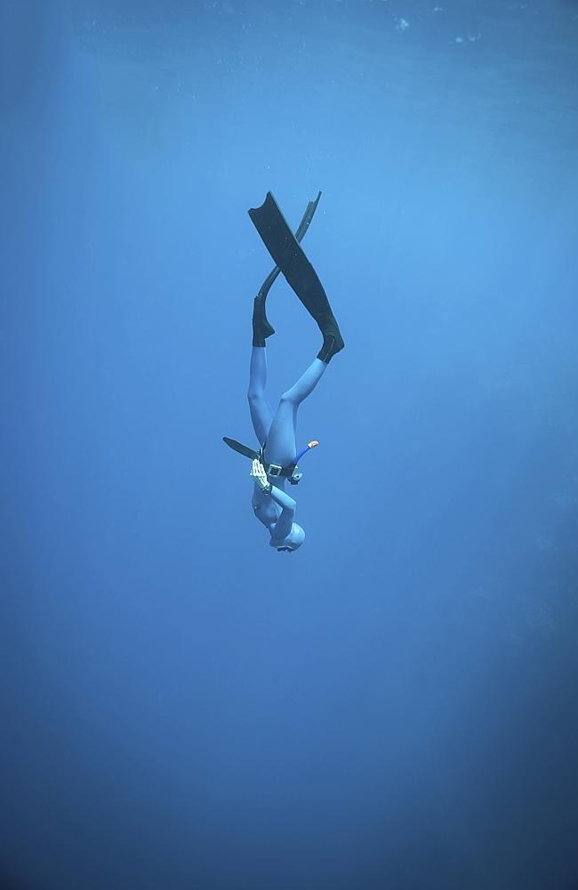 A woman freediving in the ocean.