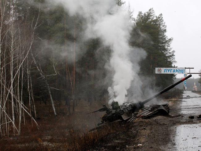 Smoke rises from a Russian tank destroyed by the Ukrainian forces on the side of a road in Lugansk region. Picture: AFP