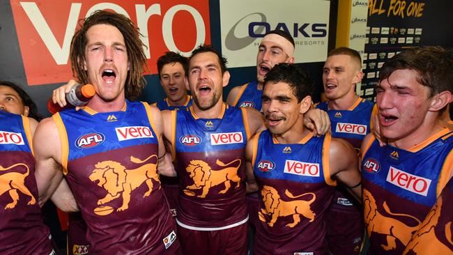 Matt Eagles (left) sings the song with Brisbane Lions teammates Luke Hodge and Charlie Cameron. Picture: AAP/Darren England