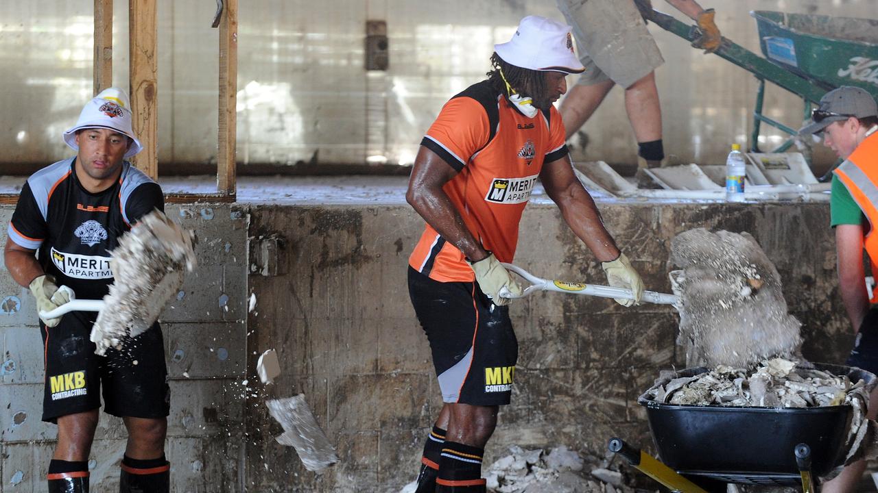 West Tigers players Benji Marshall (left) and Lote Tuqiril (right) help in the cleanup of a gymnasium in flood affected Goodna, south west of Brisbane, Tuesday, Jan. 18, 2011.