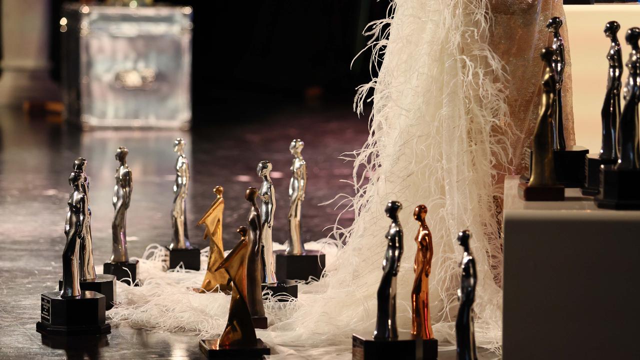 The many awards presented to the Australian Fashion Icon over the years were displayed on the stage at his funeral next to a design he was creating discovered after his death. Picture: NCA NewsWire/Tertius Pickard