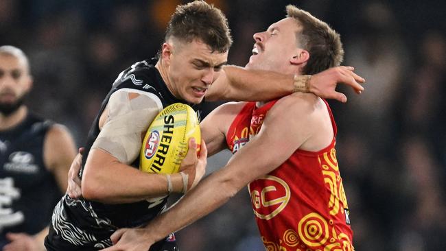 MELBOURNE, AUSTRALIA - MAY 25: Patrick Cripps of the Blues breaks a tackle attempt from Noah Anderson of the Suns during the round 11 AFL match between Carlton Blues and Gold Coast Suns at Marvel Stadium, on May 25, 2024, in Melbourne, Australia. (Photo by Daniel Pockett/Getty Images)