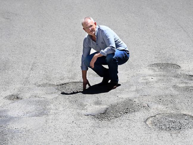 Ian Halliday, with the potholes outside his Blaxland house. Picture: Jeremy Piper