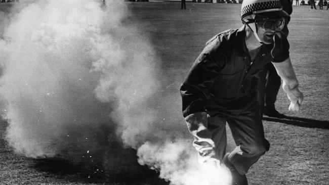 A policeman removes a smoke bomb from the ground during the 1971 Test series against the Springboks.