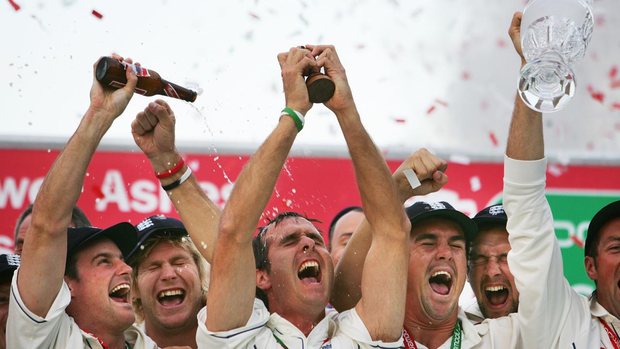 Michael Vaughan mengangkat guci The Ashes sebagai rekan satu timnya merayakan di podium kemenangan seri Inggris pada tahun 2005.