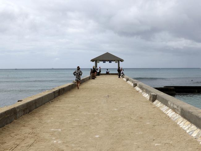 People walk on a pier in the Waikiki area of Honolulu last Friday as a siren blared in an effort to prepare tourists and residents for a possible nuclear attack from North Korea. Picture: Caleb Jones