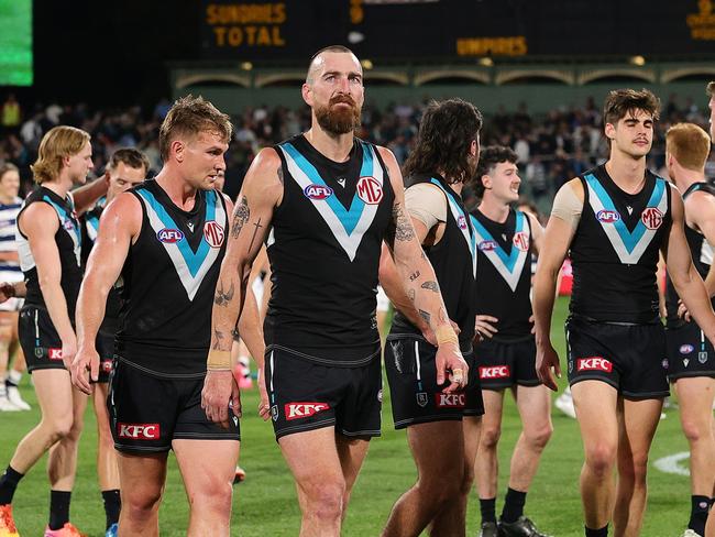 Charlie Dixon and the Power walk off the field after being pulled apart by the Cats on Thursday. Picture: Sarah Reed/AFL Photos via Getty Images.