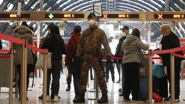 Police officers and soldiers check passengers leaving from Milan main train station in Italy overnight. Picture: AP