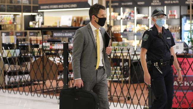 Senator Alex Antic is escorted out of Adelaide Airport on Thursday night. Picture: Dean Martin