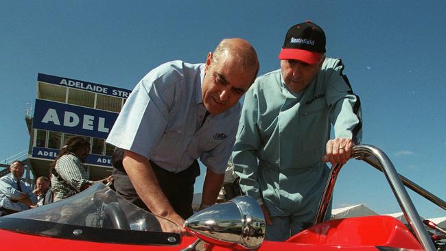 Former world champion racing driver Sir Jack Brabham, right, with the-then Premier John Olsen, left, in 1999, looking at a vintage McLaren racing car Mr Brabham drove in the first Adelaide 500 'Race of Legends'.