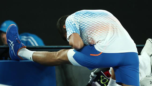 Novak Djokovic stretches him hamstring against opponent Enzo Couacaud. Picture by Michael Klein