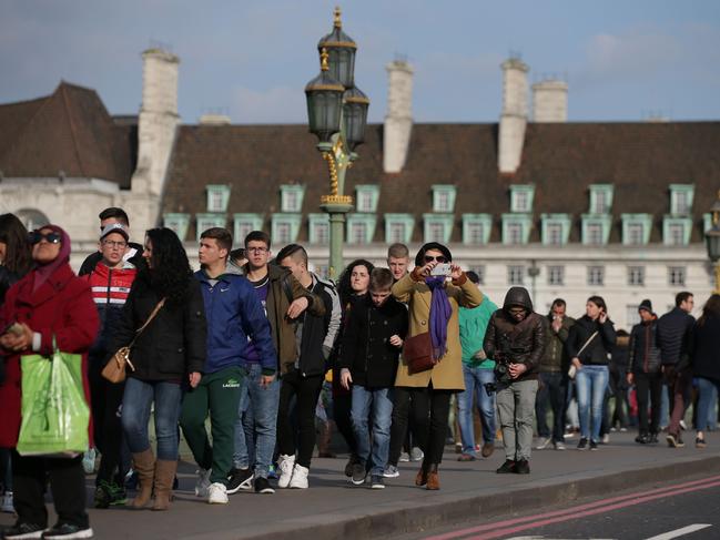 Members of the public walk along Westminster Bridge in central London on March 23, 2017 after it reopened following the March 22 terror attack at the British parliament. Picture: AFP