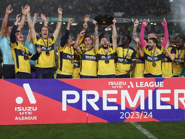 Storm Roux (centre) holds aloft the A-League Premier’s Plate as the Mariners celebrate. Picture: Scott Gardiner/Getty Images