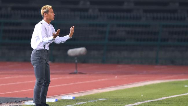 Cambodia's national football team manager Keisuke Honda (L) reacts