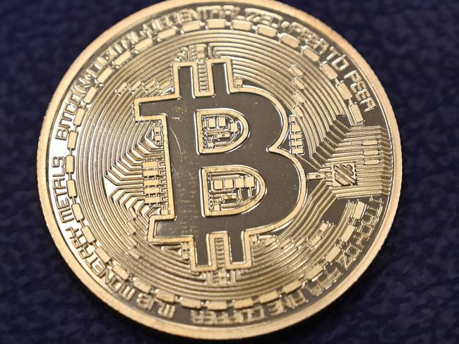 (FILES) In this file photo taken on December 17, 2020 shows shows a physical imitation of a Bitcoin at a crypto currency 