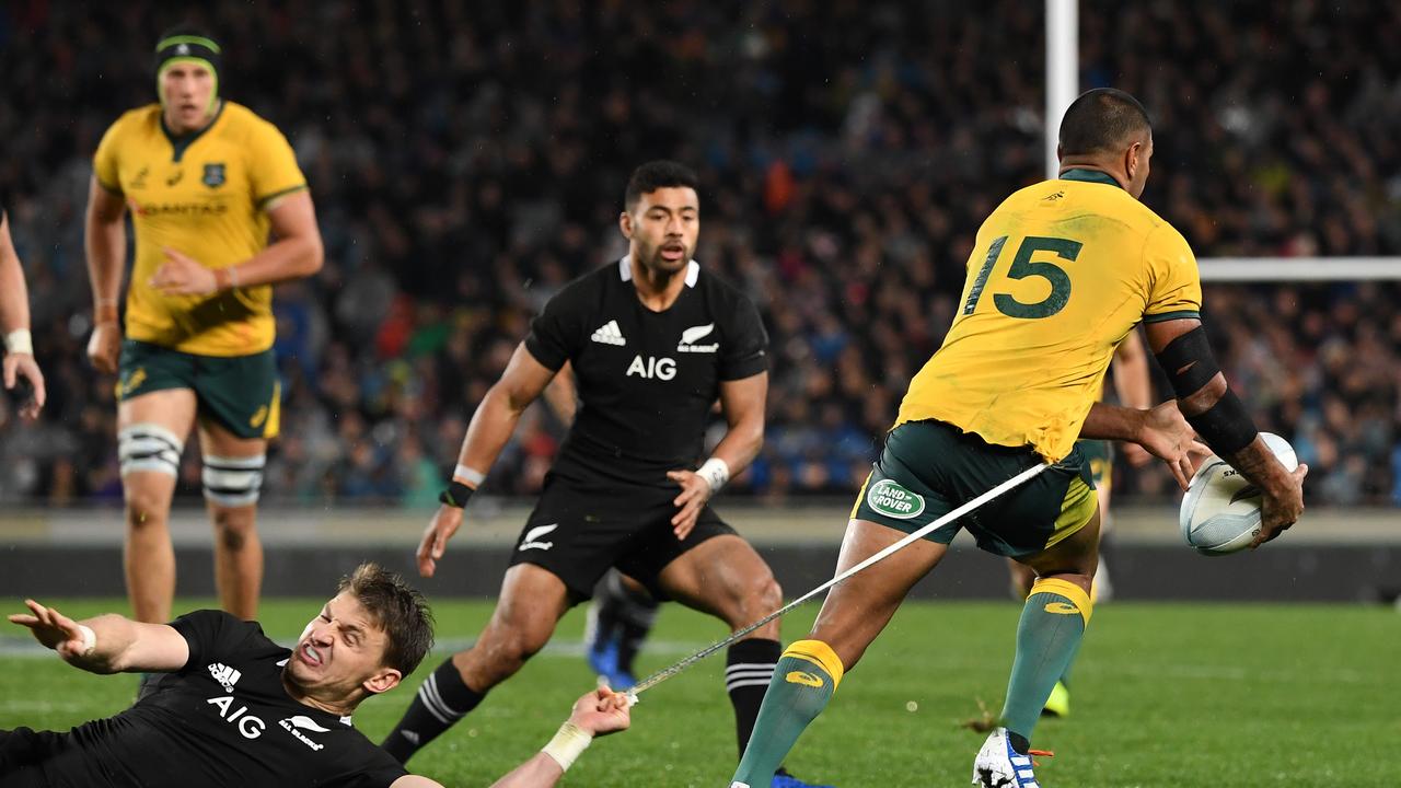 Beauden Barrett hangs onto the short strings of Kurtley Beale at Eden Park.