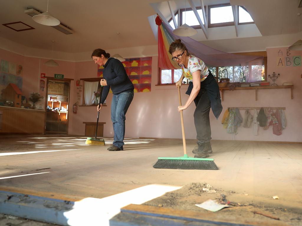 The Steiner School at Huntingfield remains closed after extensive flooding to the school. Parent Arianna Adams, left, and teacher Lindsey Gallon sweep out a classroom. Picture: SAM ROSEWARNE