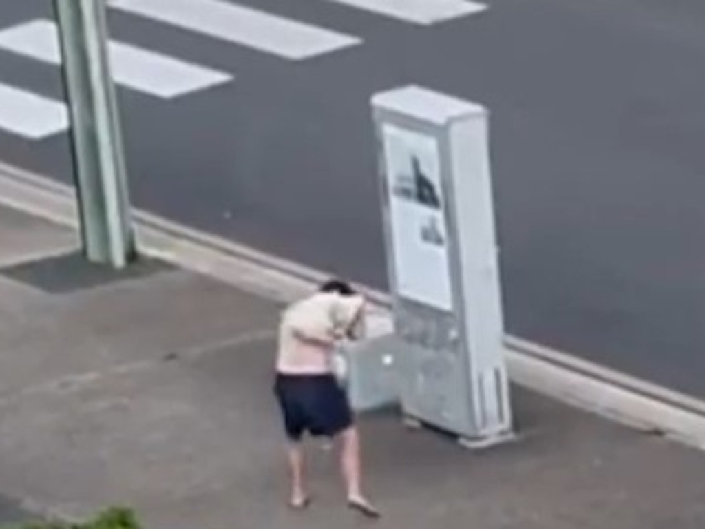 A man carrying a sack is unsteady on his feet before later stripping off and walking down Adelaide St, completely naked.