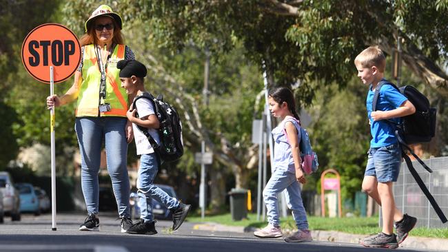 Crossing supervisor Silvana Vennerdo watches (l-r) Raj Singh (6), Ayla Eryegit (5) and (6) Angus Hay (7) cross the road. The Greens’ plan to build 1000 pedestrian crossing and extend school zone times has come under fire. Picture: Julian Smith