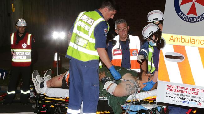 Paramedics treat the Nissan passenger on a stretcher. Picture: Bill Hearne