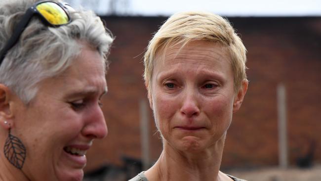 Ingrid and Deb outside the burnt out remains of their home. Picture: AAP/Dean Lewins