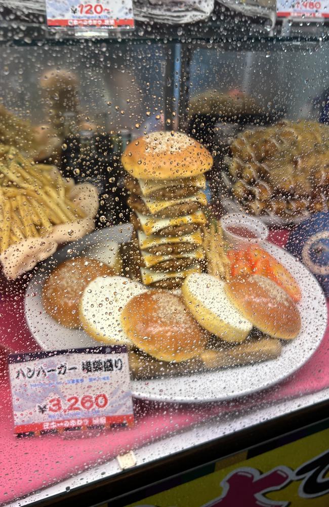 Plastic replicas of the sumo-sized meals on offer at the Yokozuna Shinsekai restaurant sit in a glass cabinet on a rainy night. This burger costs about $33. Picture: Chantelle Francis