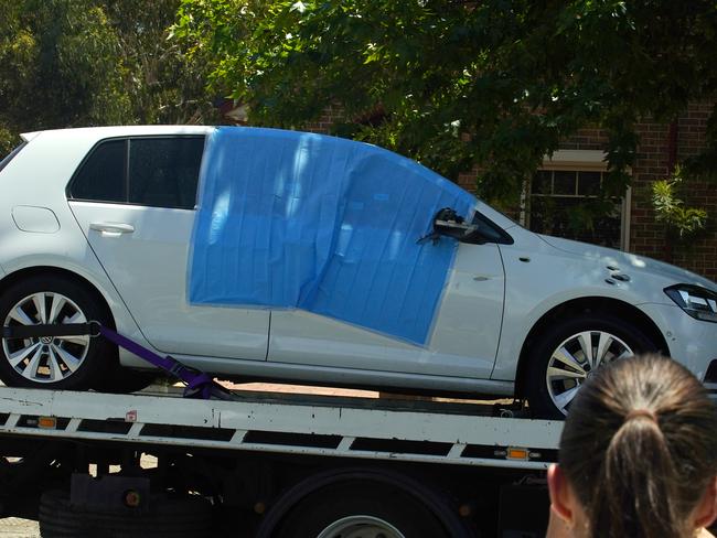 The Volkswagen, riddled with bullet holes, is removed from the scene. Picture: Luis Enrique Ascui