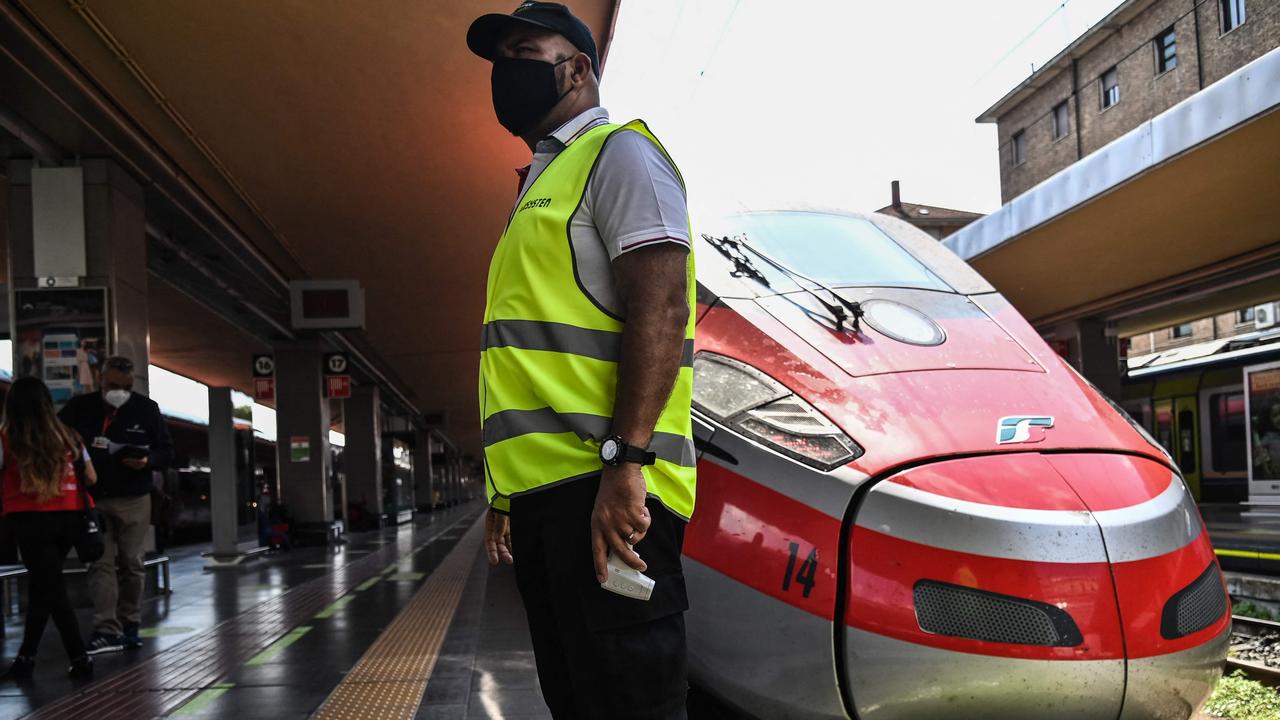 An attendant waits to check the body temperature of passengers boarding a high-speed "Frecciarossa" train at the Porta Nuova railway station in Turin. Since early August, Italy has required proof of vaccination, recent recovery from coronavirus or a negative test for people wanting to dine indoors or enter museums and sports events. Picture: Marco Bertorello / AFP