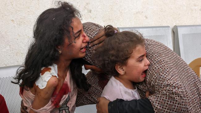 A Palestinian woman comforts her children as they wait at the hospital to be checked. Picture: AFP