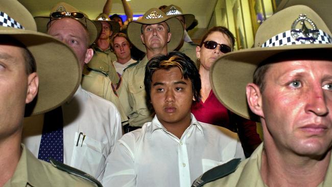 Phu Ngoc Trinh is escorted by police and detectives through Darwin Airport.