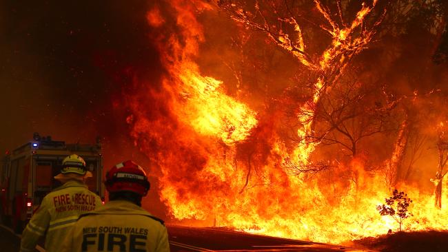 Fire and Rescue personal run to move their truck as a bushfire approaches on the outskirts of Bilpin. Picture: Getty Images.