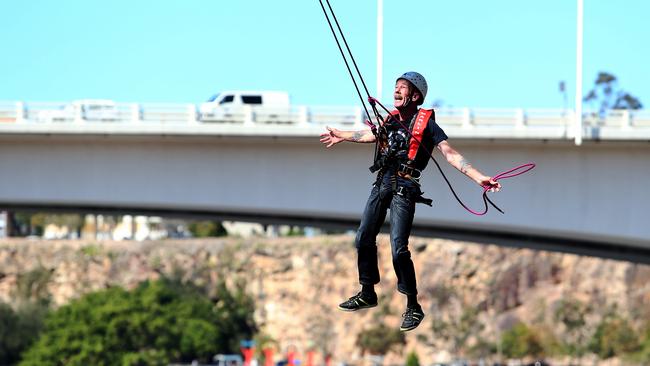 Pat Kinsella who has ALS/ MND swinging from the Goodwill Bridge to raise awareness on the disease. Photo: Jodie Richter