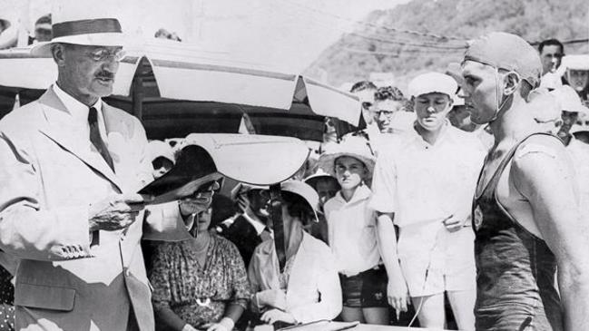 The Governor of Queensland, Sir Leslie Wilson, presents Joe Doniger with a Gallantry Award for Bravery for his efforts in trying to save the victims of double shark attack off Kirra in 1937.