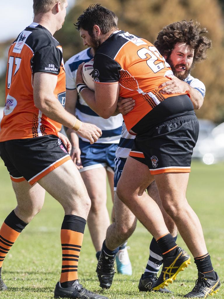 Heath Tisdell of Southern Suburbs is tackled in the game against Brothers.