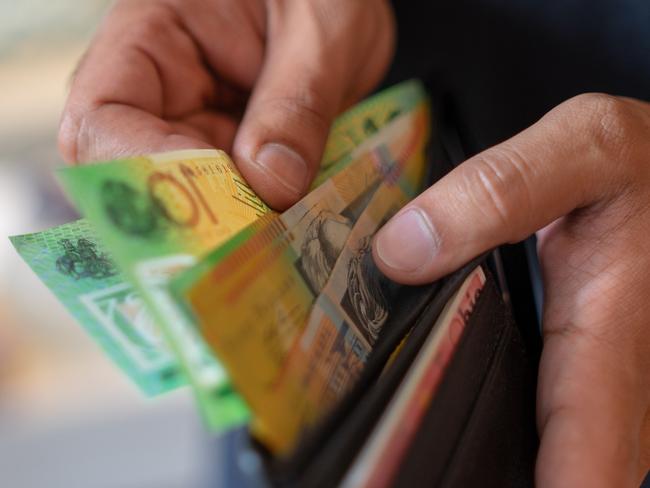 a male taking money out of a wallet, Australian cash generic spending