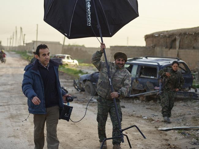 Jan Ezidxelo and Mehmud of the YPG assist photographer Joey Lawrence in Tel Hamis, Syria