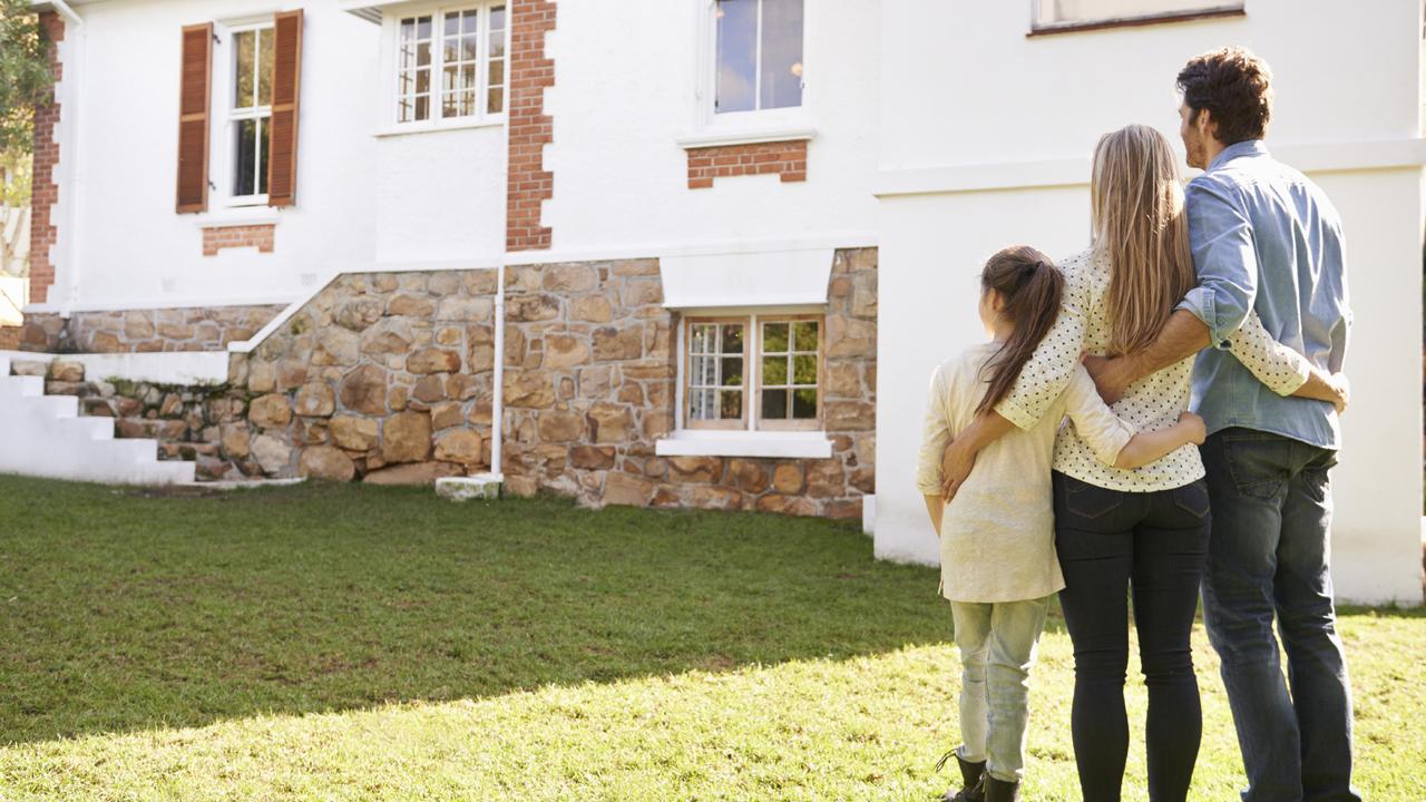 A family standing outdoors admiring their new home