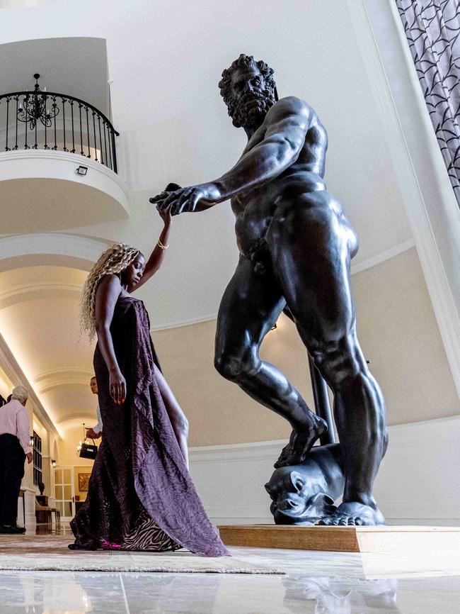 Actor Suzan Mutesi with the statue of Neptune in the entry that comes with the home. Picture: Luke Marsden