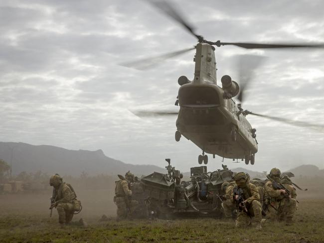 This handout photo taken on March 26, 2023, by Australian Defence Force shows an Australian Army Chinook helicopter flying over soldiers after moving an artillery gun during Exercise Talisman Sabre 2023 at Shoalwater Bay Training Area in northern Queensland. Australia on September 12, 2024, moved to strip medals from war commanders whose units were involved in alleged war crimes and "unlawful conduct" in Afghanistan. (Photo by Handout / Australian Defence Force / AFP) / ----EDITORS NOTE ----RESTRICTED TO EDITORIAL USE MANDATORY CREDIT "AFP PHOTO / AUSTRALIAN DEFENCE FORCEâ NO MARKETING NO ADVERTISING CAMPAIGNS - DISTRIBUTED AS A SERVICE TO CLIENTS