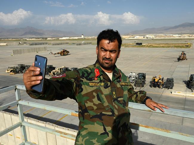 TOPSHOT - An Afghan National Army (ANA) soldier takes a selfie with his mobile phone inside the Bagram US air base after all US and NATO troops left, some 70 Kms north of Kabul on July 5, 2021. (Photo by WAKIL KOHSAR / AFP)