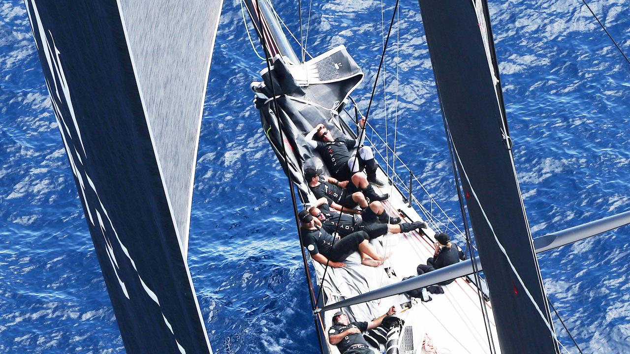 The crew aboard Perpetual Loyal rest on the bow during light conditions on a previous race to Hobart.