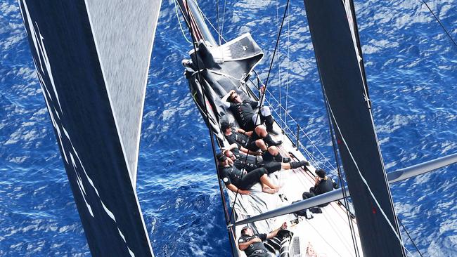 The crew aboard Perpetual Loyal rest on the bow during light conditions on a previous race to Hobart.