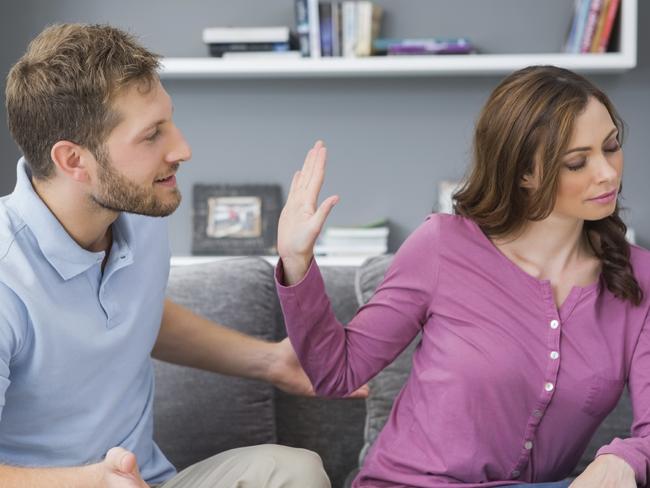 Woman refusing to listen to partner during a fight at home on the couch