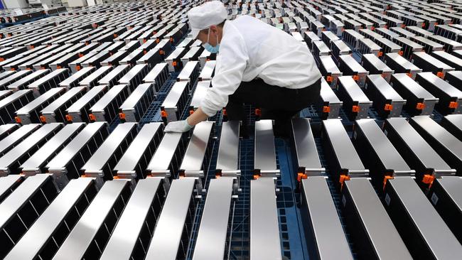 (FILES) This file photo taken on March 12, 2021 shows a worker with car batteries at a factory for Xinwangda Electric Vehicle Battery Co. Ltd, which makes lithium batteries for electric cars and other uses, in Nanjing in China's eastern Jiangsu province. - Lithium, cobalt and nickel, the metals that are essential to the manufacture of the electric batteries that will replace the combustion engines that contribute to global warming, are so sought after that Europe is preparing to open mines and refineries to try to reduce its dependence on imports. (Photo by AFP) / China OUT